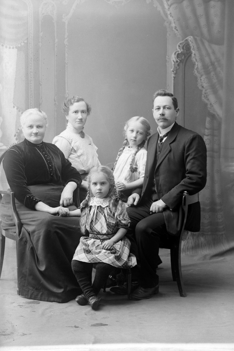 Studioportrett av en eldre kvinne med en mann, en kvinne og to barn.