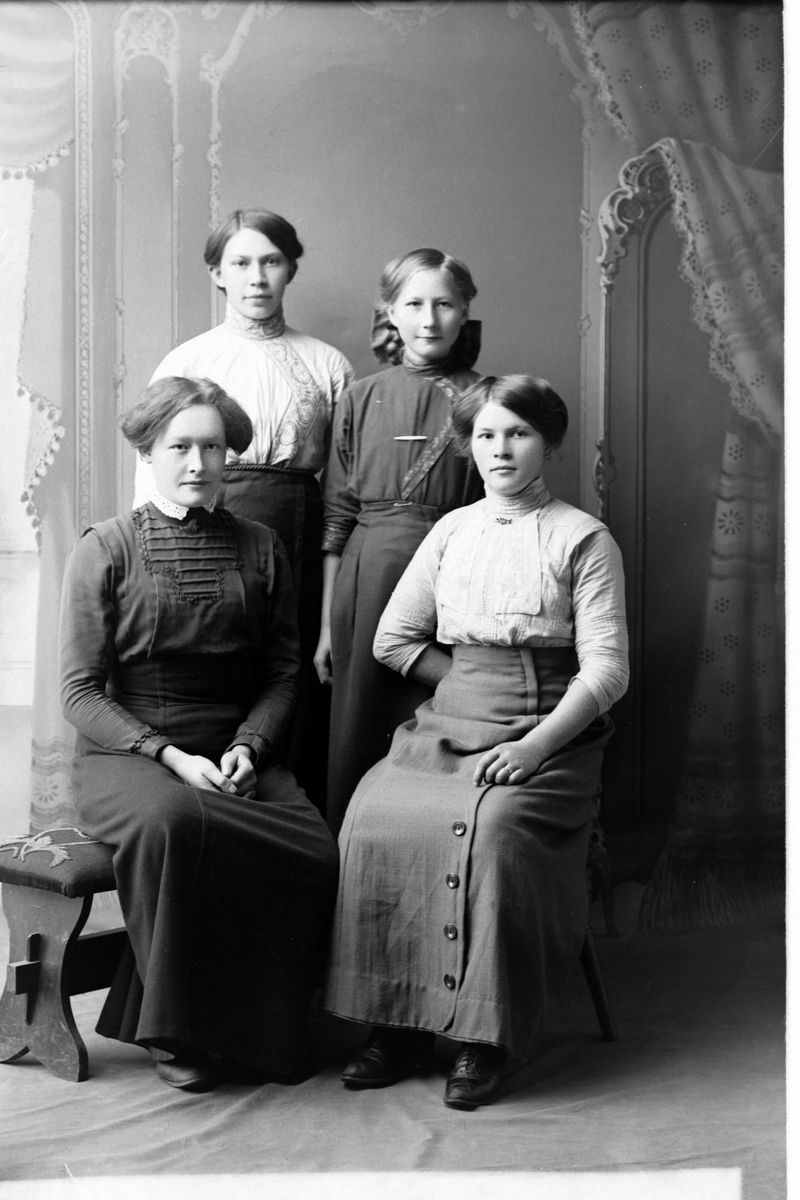 Studioportrett av fire kvinner i helfigur.
