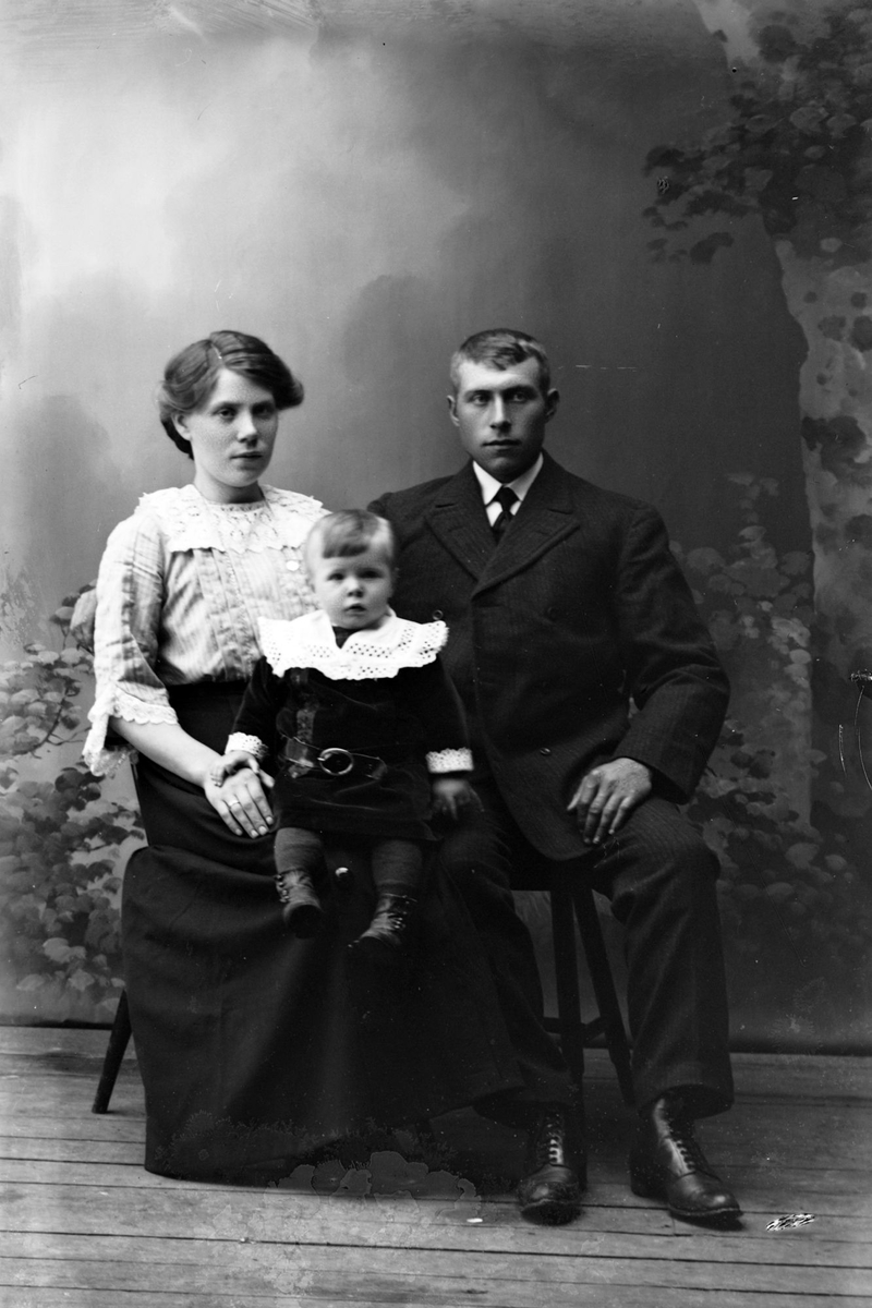 Studioportrett av en mann og kvinne med et barn.