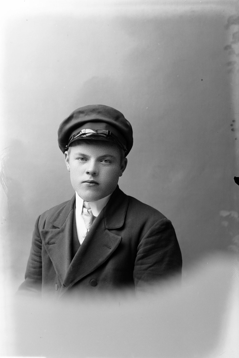 Studioportrett av en ung mann i halvfigur.