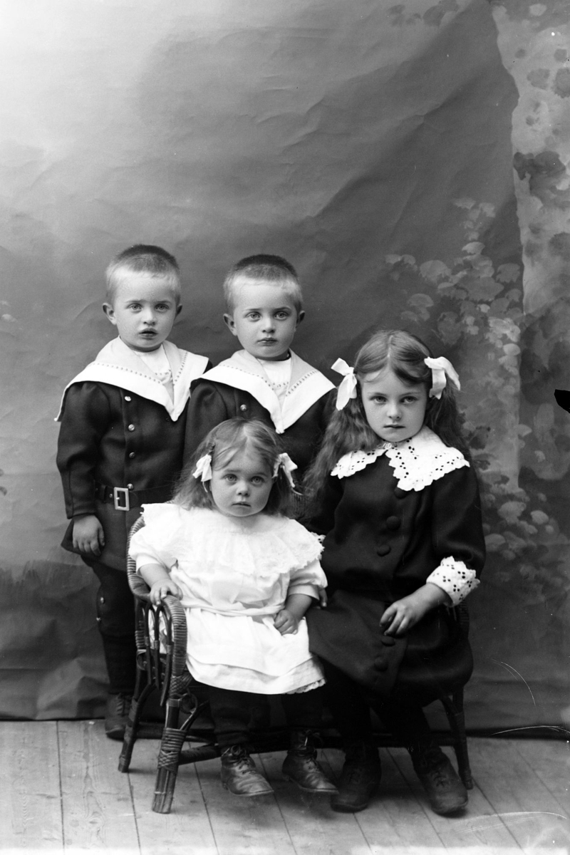 Studioportrett av fire barn i helfigur.