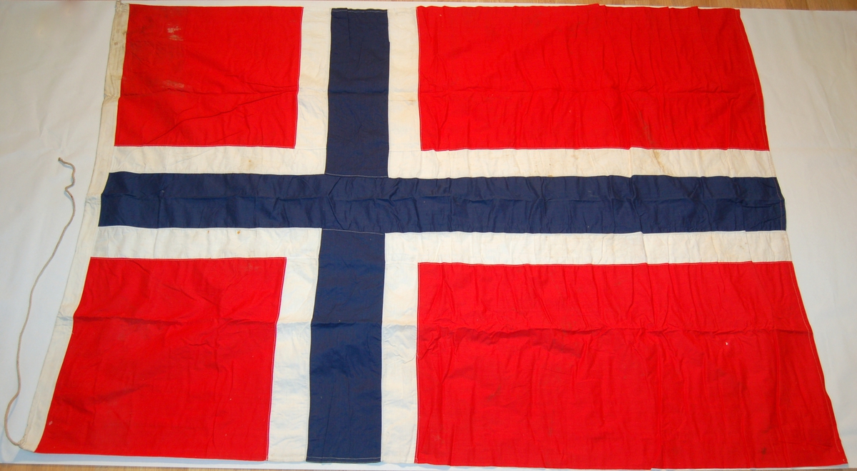 Norsk nasjonalflagg. Blått og kvitt kors på rød bunn.