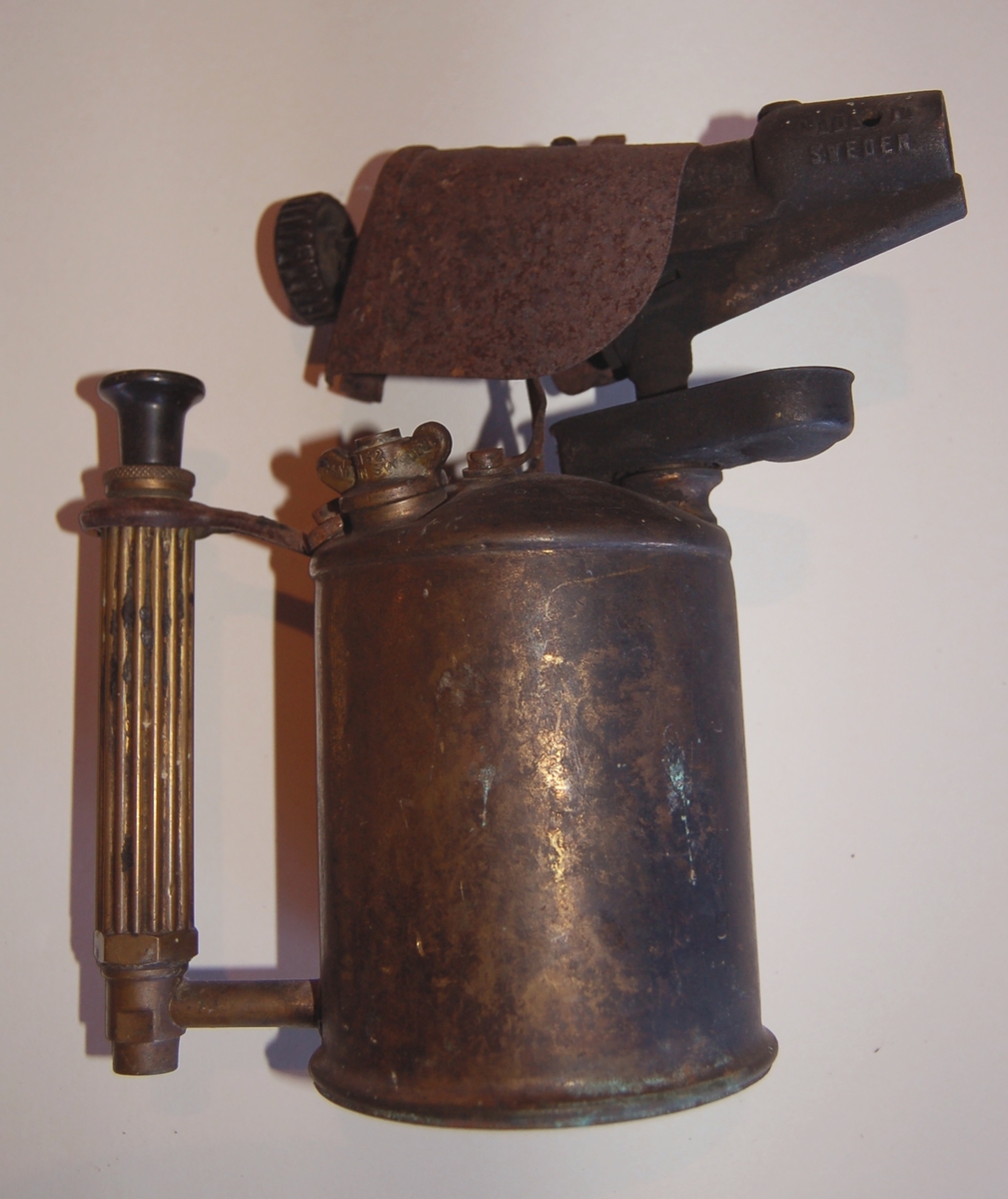 Blåselampen har form av en "Kanne/Mugge", der brenneren utgjer "tuten", og i handtaket er det innmontert en handpumpe for tilførsel av parafin til brenneren.