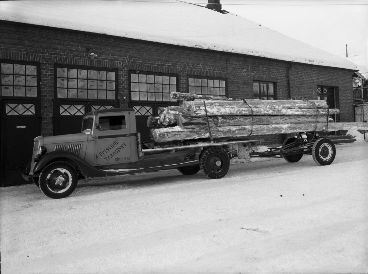 Lastebil fra "Fristads Transport" som transporterer tømmer.
Ford V8 årsmodell 1935 med norskbygd førerhus.