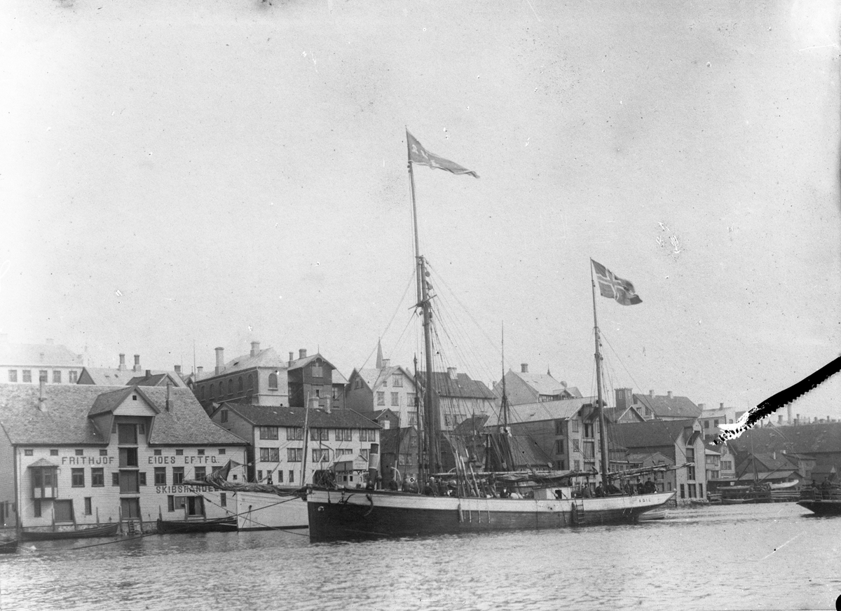 Sluppen "Ægil" i Smedasundet, Haugesund. "Ægil" har flagg i toppen av begge mastene, men seilene er tatt ned.
