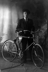 Studioportrett av en gutt med en sykkel.