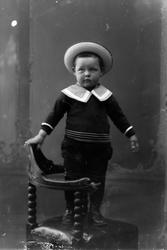 Studioportrett av et lite barn med hatt på hodet.