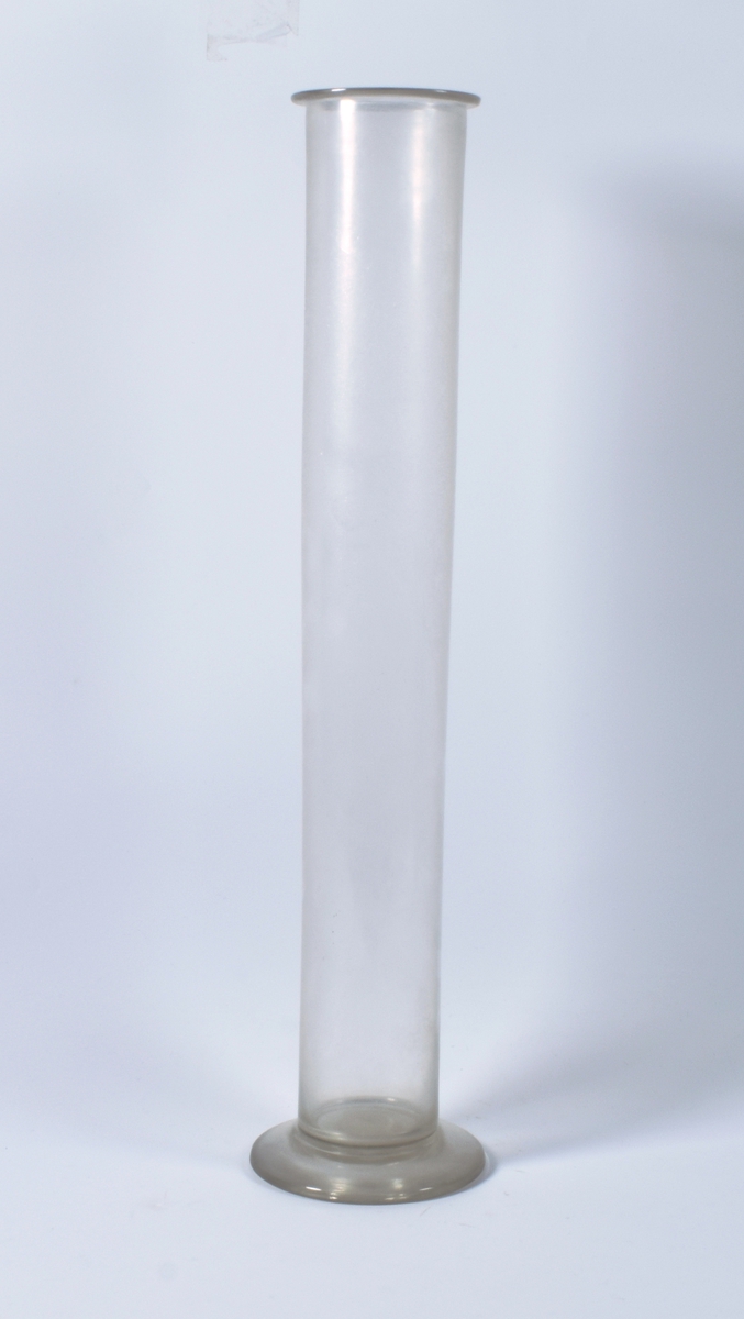 Høyt glassrør i klart glass som sluttes av en smal horisontal kant. Selve røret har samme bredde fra nederst til øverst. Nederst går røret ut i en flat sokkel.

Gjenstanden kan være den ytre sylinder av et Jørgensens luftutviklingsapparat som brukes som VAF 13467, men har en helt annen konstruksjon enn denne.