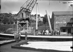 Lasteskip med bjelker fotografert, "Felleskjøpet" i bakgrunn