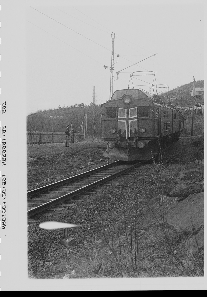 NSB elektrisk lokomotiv type El 3 kommer med de første  polititroppene til Narvik, pyntet med splittflagg.