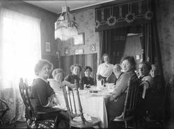 Gruppe samlet ved et bord i stuen. Magdalene nr.3 fra venstr