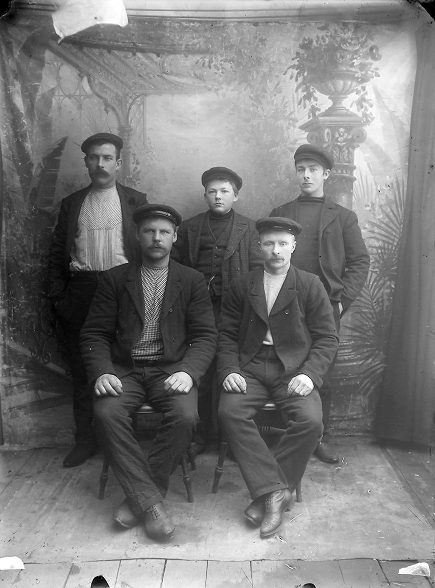 Portrett. 5 personer. To sitter, de andre står bak. Tre menn i 20-30-åra, to gutter i tenårene.Bildet er tatt i Lofoten.