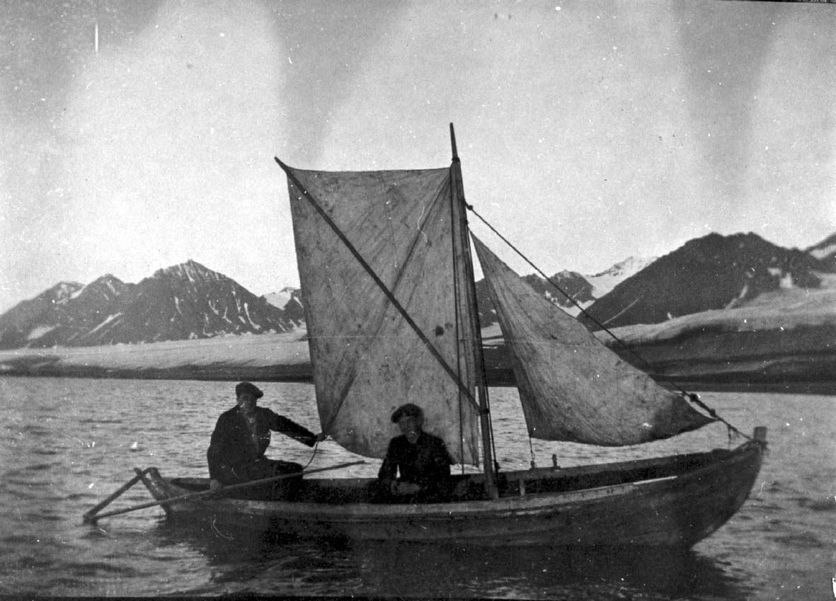 Portrett, 2 personer ombord i en mindre båt med seil.