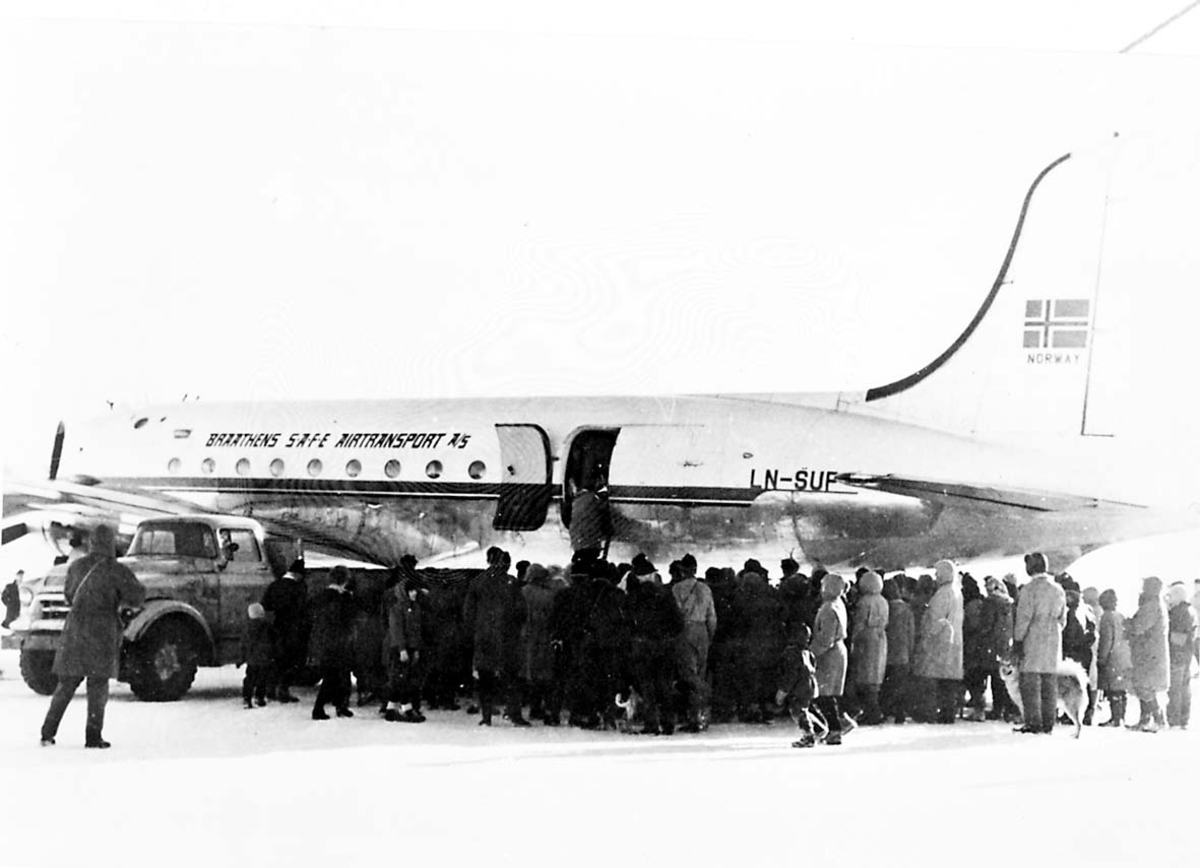 Lufthavn. 1 fly på bakken DC-4 Douglasc C-54 Skymaster LN-SUP "Norce Commander" fra Braathens SAFE. Flere personer ved flyet.