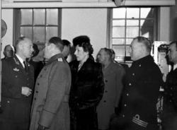 Gruppebilde. Flere personer, menn og kvinne. Mennene i milit