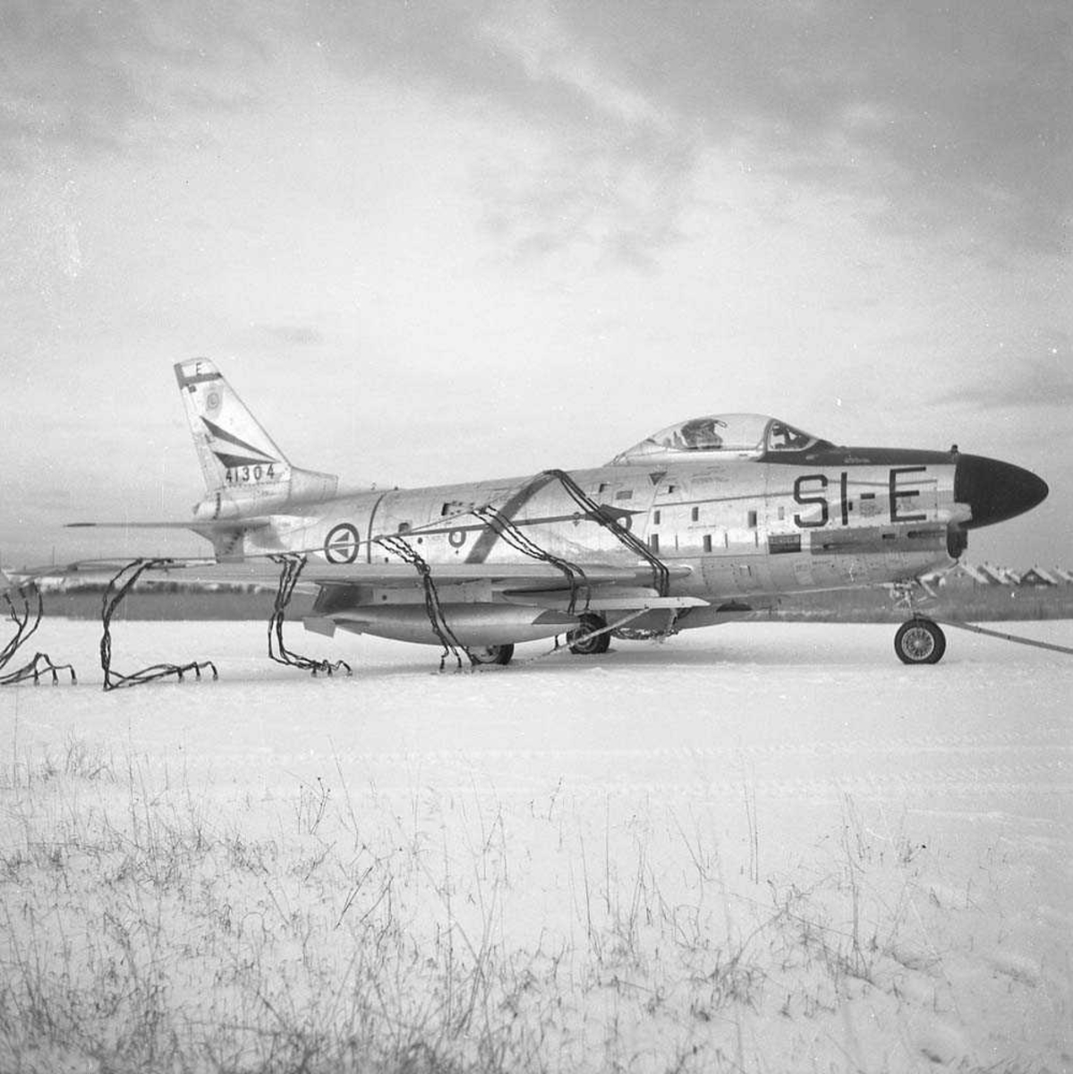 F-86-K, SI-E, tail nr. 54-1304, i nettet på Bodø flystasjon. Flyet tilhørte 339 skvadron, Bardufoss flystasjon.
Se også NL.05060373.