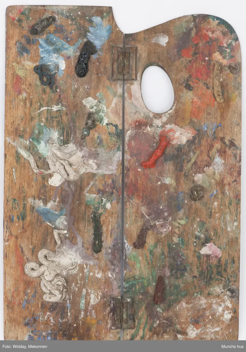 Malepalett i tre. Paletten er brukt og har mange spor av maling i ulike farger.