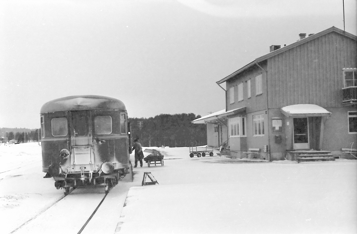 Tog 371 (Hamar - Røros) på Os stasjon. Posten lempes ut av betjent postvogn. Styrevogn BDFS 91 71 eller 91 73. Os i Østerdalen.