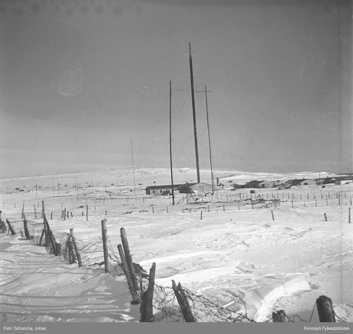 Radiomastene i Vadsø fotografert på vinter -46. Brakkehus. Kringkastingshus ble bombet natt til 3. juni 1940 og kringkasting hold hus i et brakkehus. Mastene står skjevt. Nederst på bildet piggtrådgjerde.