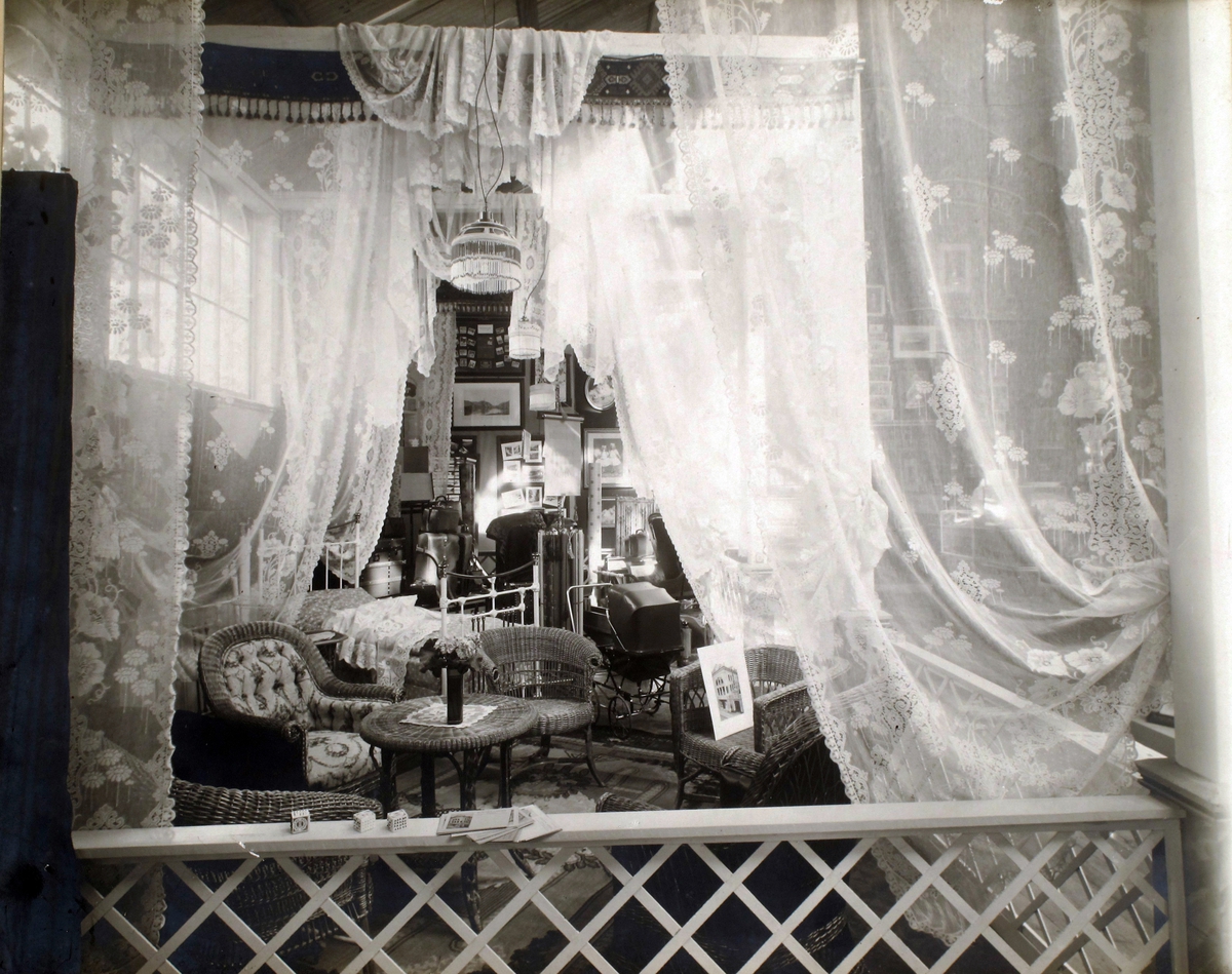 Utstilling, Joachim Larsens stand i Arendalsutstillingen 1911 , interiør med kurvstoler, bord, tekstiler m.m.
