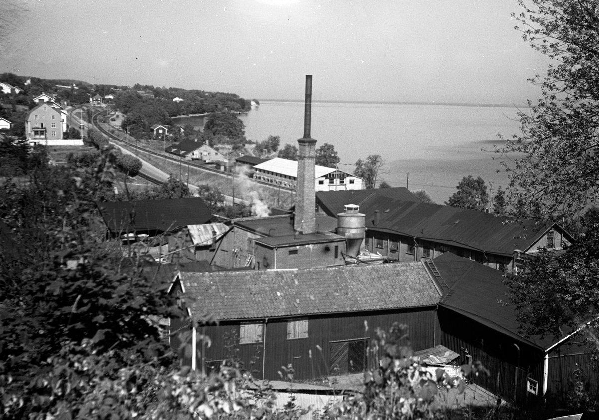 Järnvägen går utmed Vätterns västra sida i Jönköping förbi bostäder och industrier, bland annat snickerifabriken vid Talavid. Det långa huset på andra sidan järnvägen, mot Vättern, är Bröderna Ljungqvist i Jönköping AB, vanligen kallad för Blecket, då de tillverkade hushållsföremål i bleckplåt.