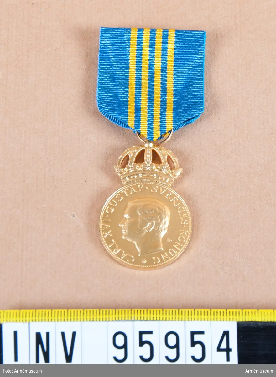 Svenska Värnpliktsofficersförbundets kungliga förtjänstmedalj i guld, 8:e storleken.

Band: blått med fyra smala gula ränder på mitten.