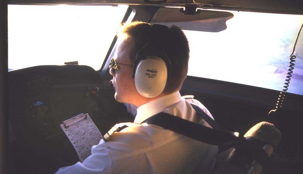 Luftfoto. Flystyrmann/pilot. Ett fly, DHC-7-102 / Dash7 fra Widerøe.