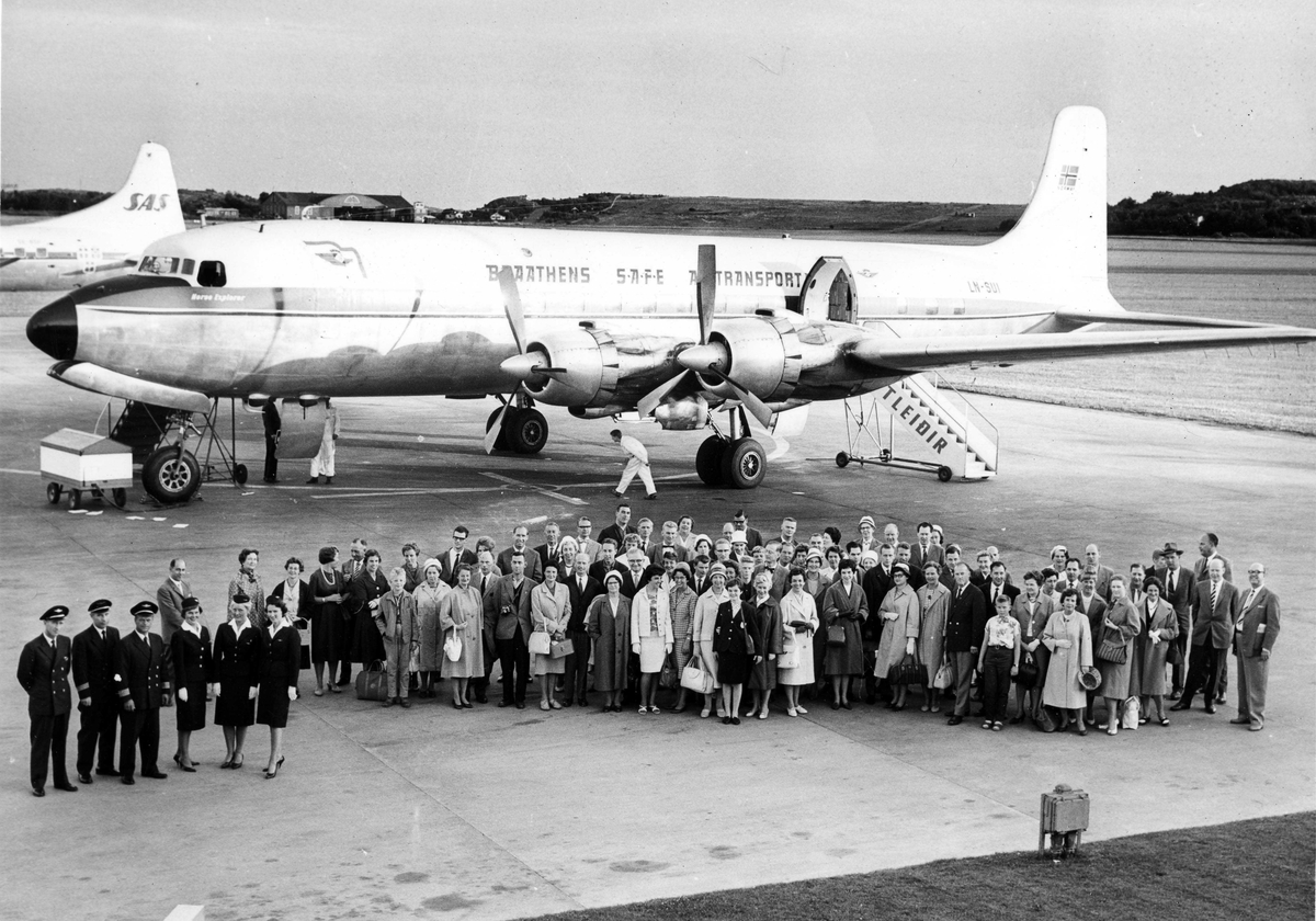 Lufthavn. En gruppe personer som står foran ett fly på bakken, Douglas DC-6 LN-SUI fra Braathens SAFE.