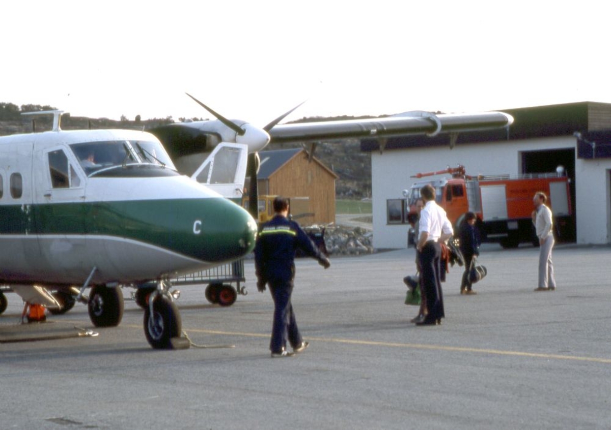 Lufthavn (flyplass). Et fly, LN-WFC, DHC-6-300 Twin Otter fra Widerøe. Flere personer utenfor flyet,bl.a. flyger (pilot) og lufthavnbetjent.