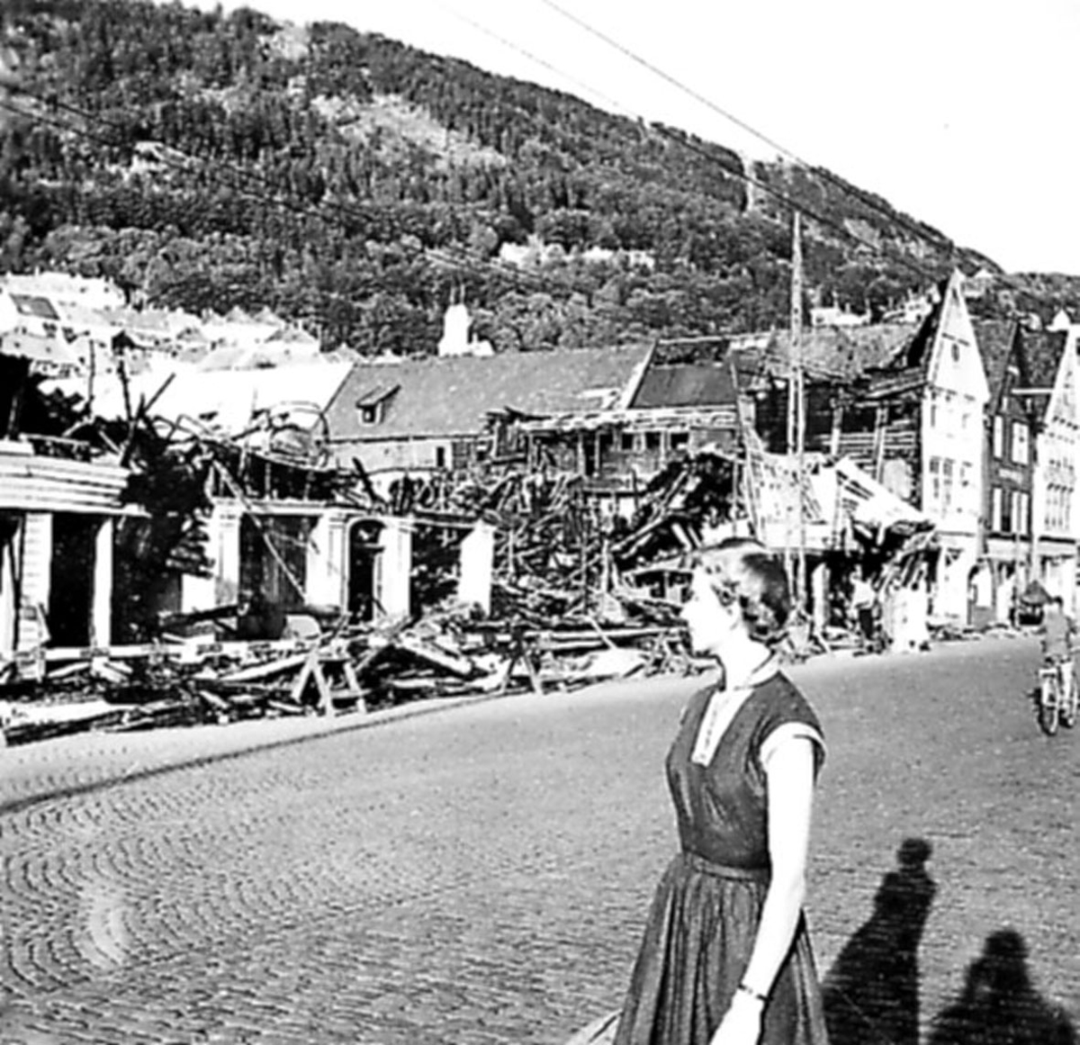 Tettsted, en person foran ruiner av flere bygninger, "Tyskerbryggen". 