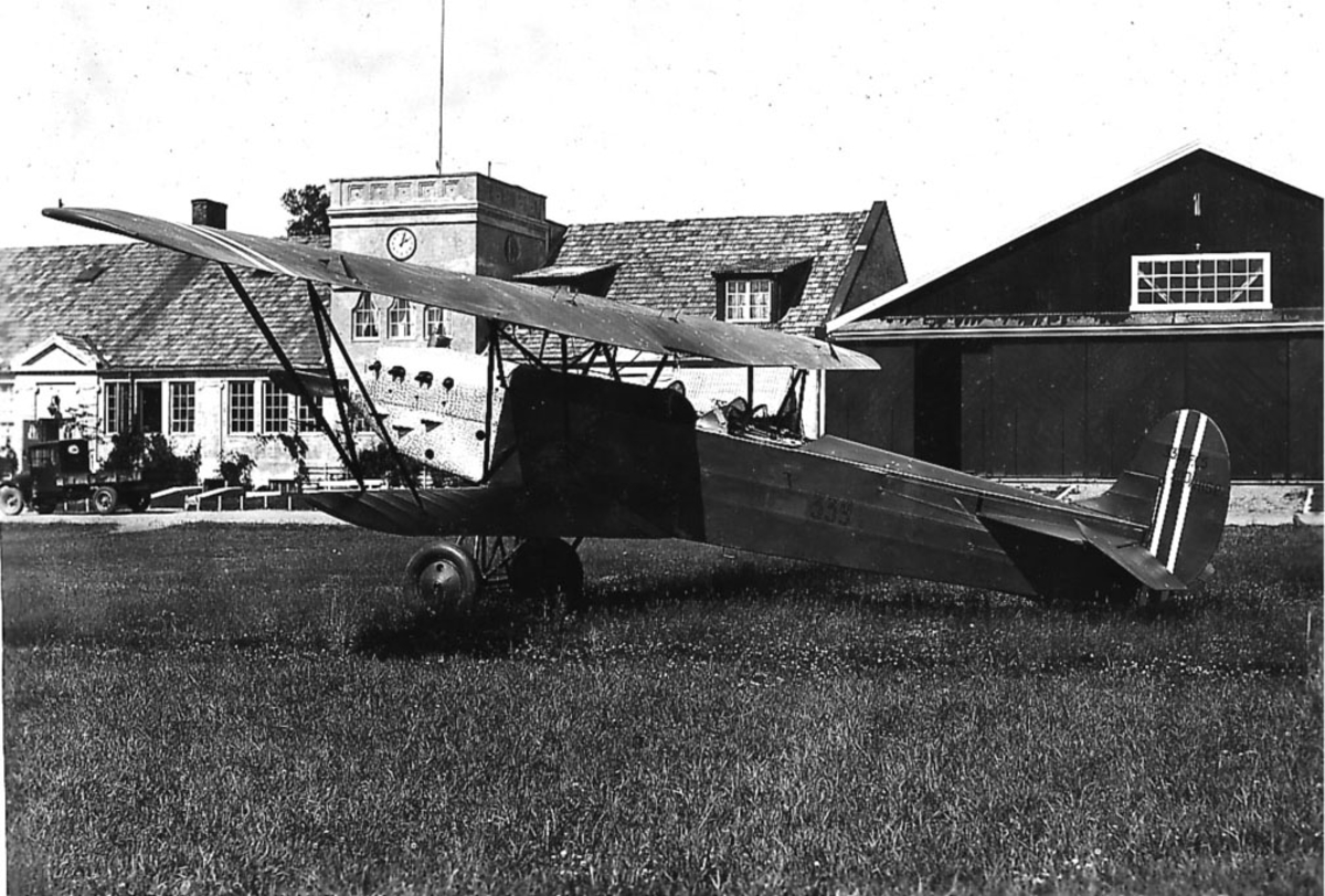 Kjeller lufthavn. En Fokker CVE nr 339 på bakken, bygninger i bakgrunnen 