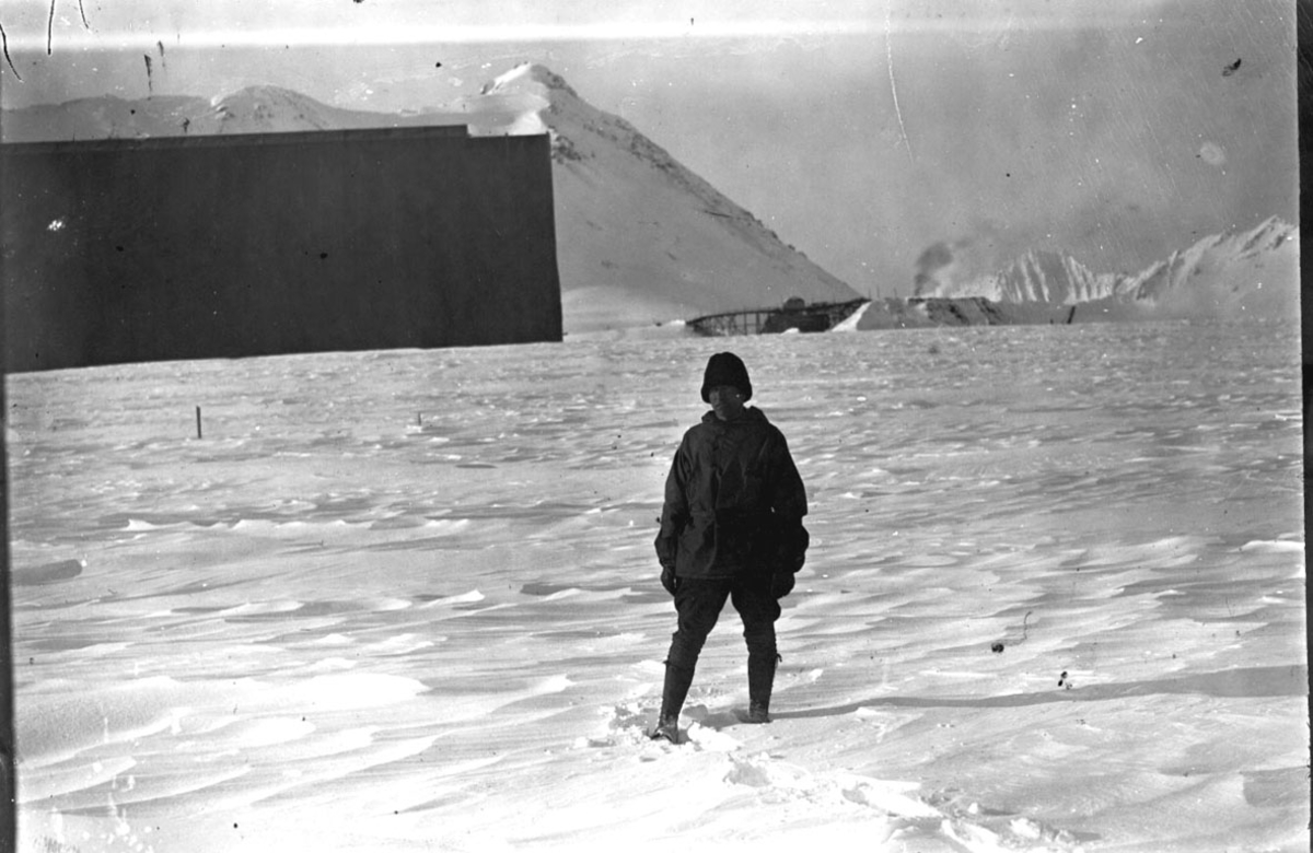 Luftskipshangaren bak t.v., sett fra siden. Ferdig trukket med seilduk. En person i forgrunnen. Snø på bakken.