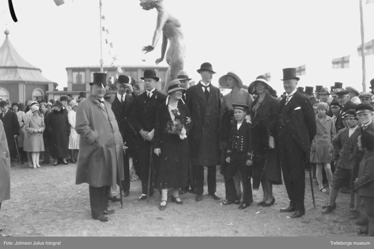 Axel Ebbes skulptur Famntaget inviges vid Solfjädern i juni år 1930. Skulptör Axel Ebbe är den långe mannen mitt i bilden, precis till höger om Famntaget. Från vänster Albert Holmquists familj, Albert disponent på Trelleborgs gummifabrik 1905-1939, Sven(son), Gösta(son), Julia(hustru), Axel?(son,delvis skymd), Axel Ebbe (konstnär), Birgit (dotter, Uma Thurmans mormor), Rut (dotter, skapare av fågelbadet som finns söder om rådhuset), Torsten Ljungbeck (rådman), pojken framför är Lennart (son).