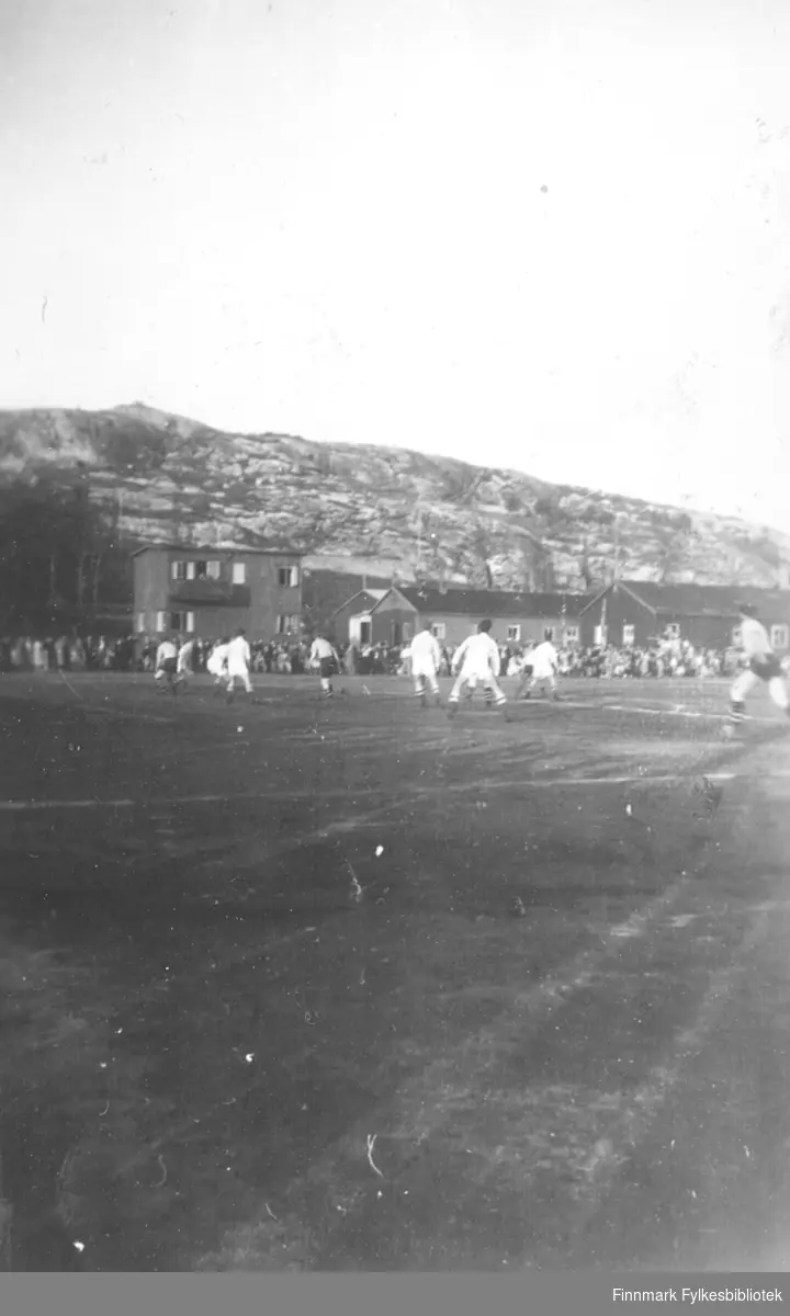 Fotballkamp mellom Kirkenes idrettsforening (KIF) og Vadsø turnforening på Kirkenes, ca. 1949-1950. VTFs lag i svarte bukser