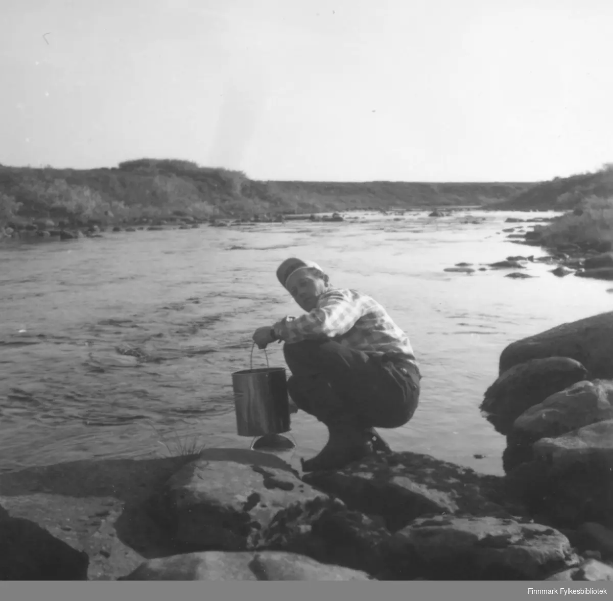 Fritz Ebeltoft henter vann i Ridelva, ca. 1962-1963. Familien hadde hytte i Skallelv