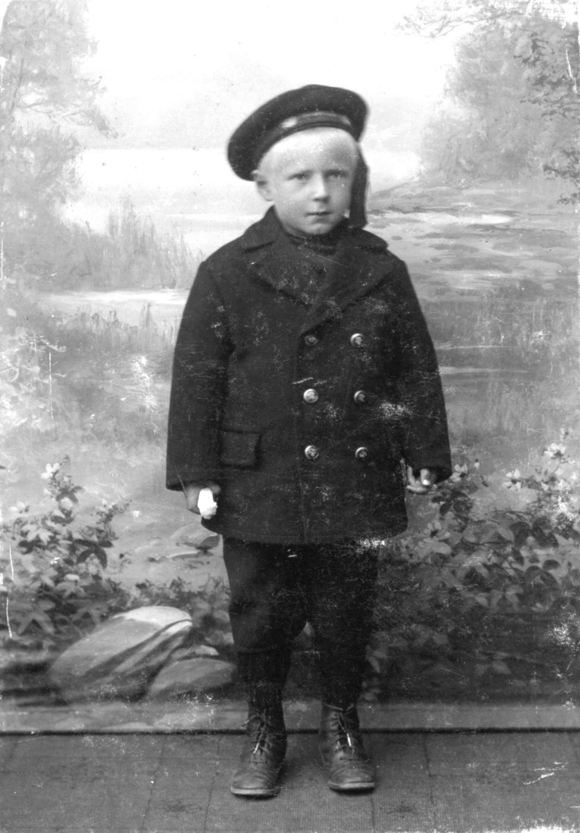 Portrett fra Godtfred Pedersen fotografet hos Emilie Henriksen. På bildet er han 5 år gammel. Han har jakke, lue og skoan på seg.