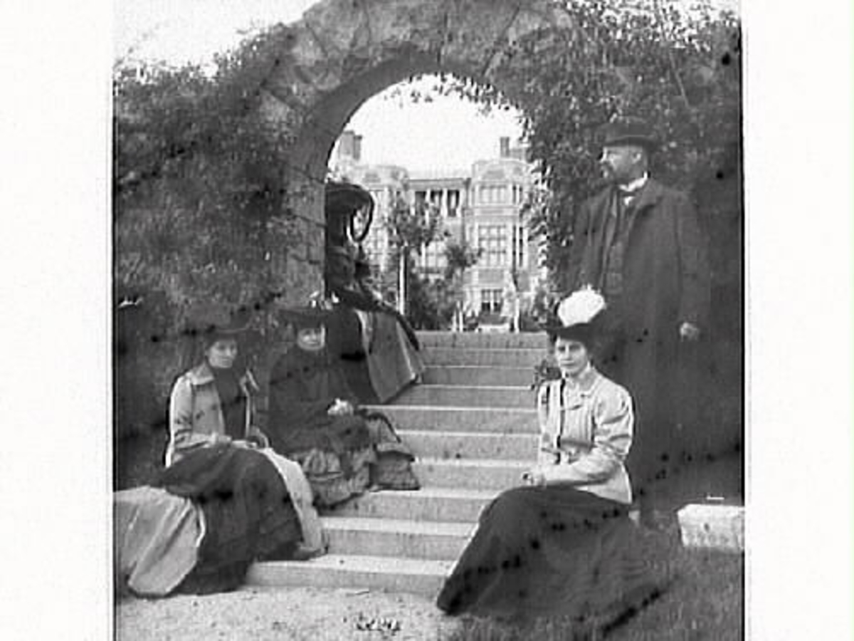 Fotograf Mathilda Ranch besöker Tjolöholms slott 1906 och ses här sitta bakom portalen. Systern Hulda Lindh sitter längst till vänster. Slottet var nyligen färdigställt (1904) men ägarinnan Blanche Dickson dog oväntat den 21 maj 1906.