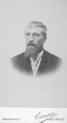 Portrett av en ukjent mann med bart og skjegg. Han er kledt 