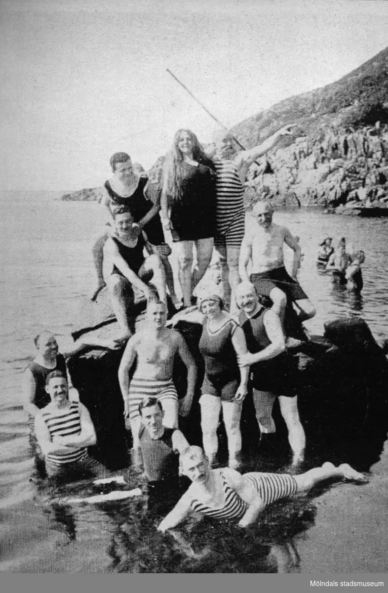 Badklädda personer poserar ståendes på något i vattnet, troligtvis vid Stenungsön, cirka 1930.