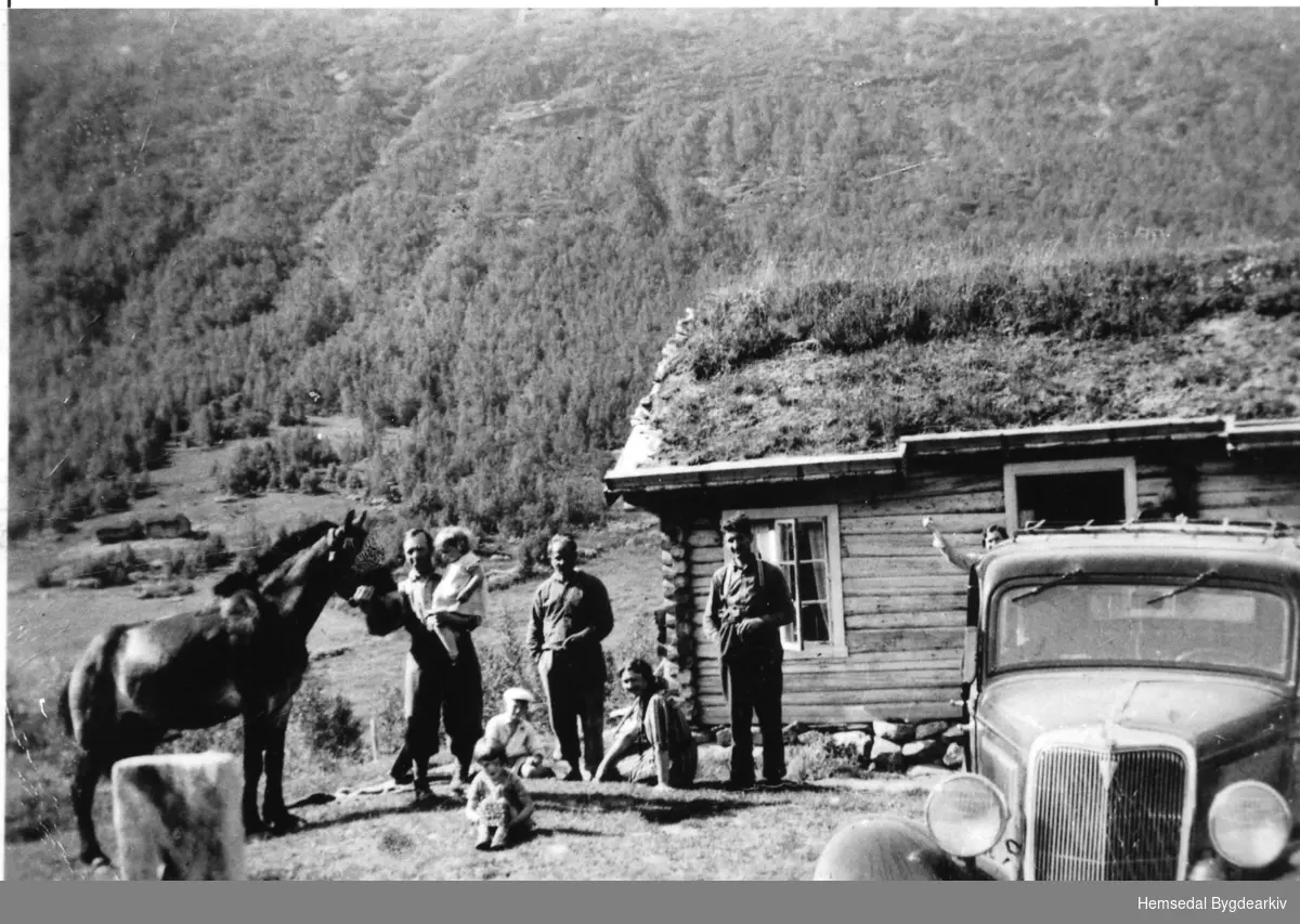 Hustadstølen 79/2 i Mørkedalen i Hemsedal i 1938.
Frå venstre: Erling Nielsen med Anne Lise, Mekkel Hustad og Lasse Mo