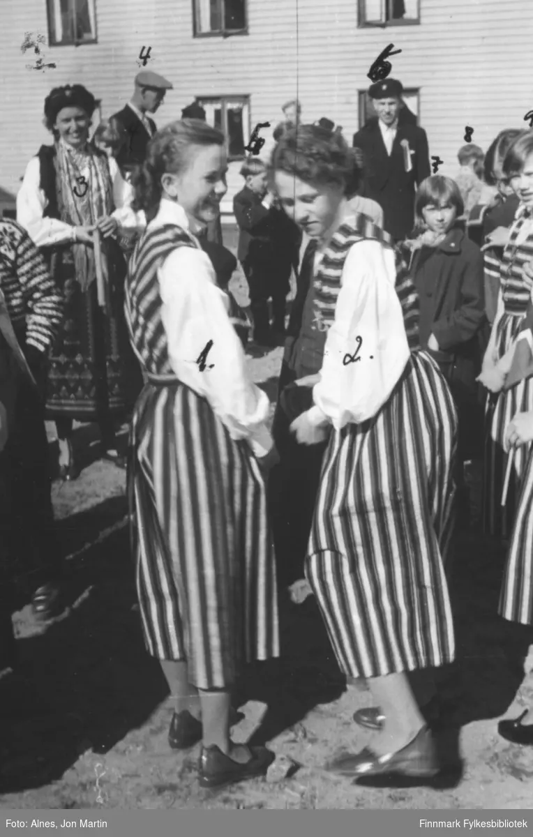 17. maifeiring i Øksfjord i 1953. I forgrunnen flere jenter med like drakter som de hadde sydd i håndarbeidstimene. Bildet er tatt utenfor Messa