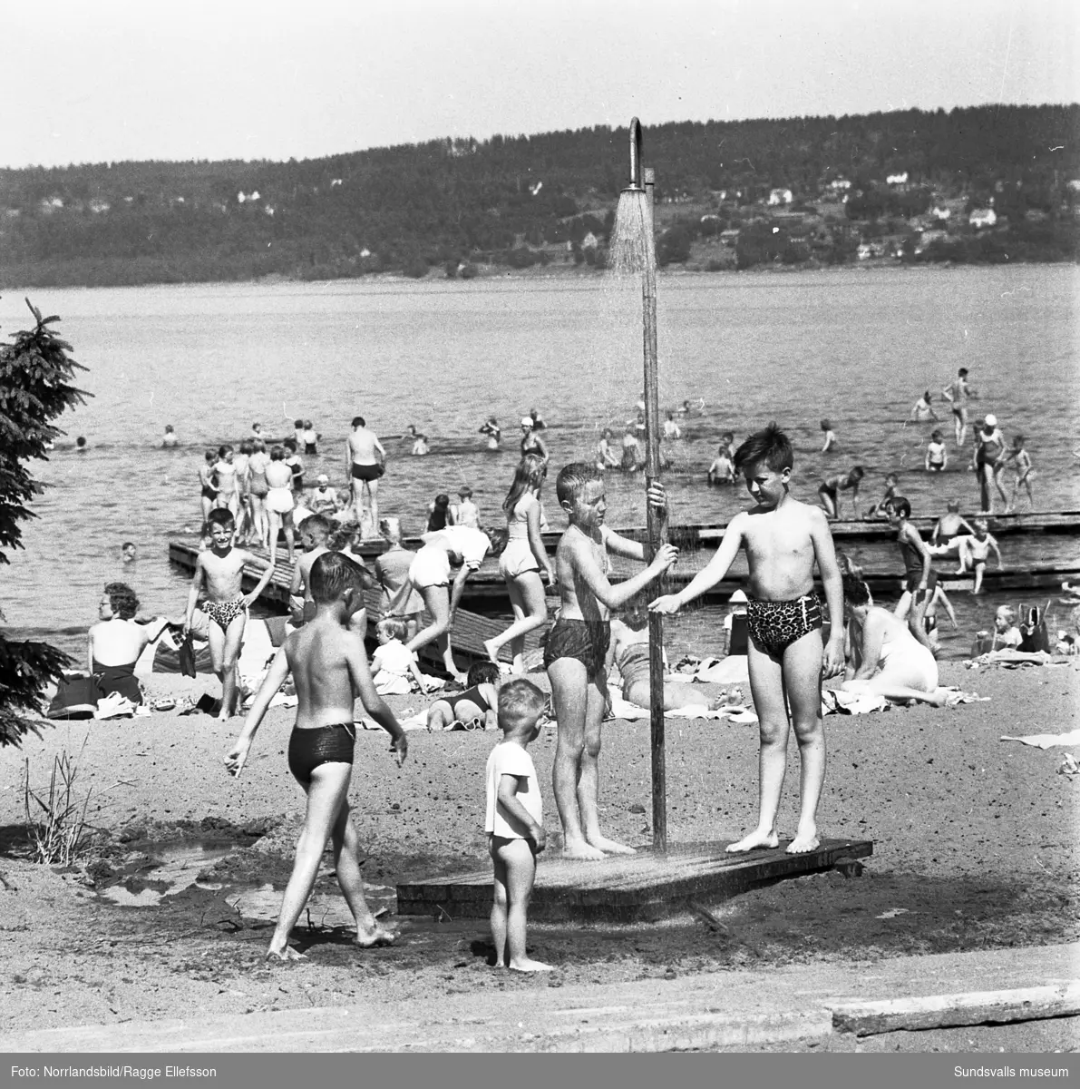 Turister och sommarlediga Sundsvallsbor vid badplatsen i Fläsian.