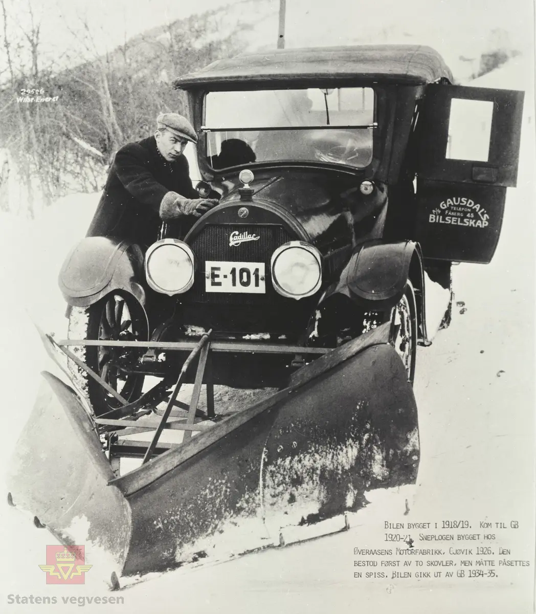 Cadillac med kjennetegn E-101 og påmontert snøplog, ca. 1926-1930. Sjåfør Arne Haugeng fra Østre Gausdal. Bilen er en 1919 modell og kom til AS Gausdal Bilselskap i 1920-21. Snøplogen er bygget på Øveraasen Motorfabrikk på Gjøvik i 1926. Den besto først av to skovler foran hvert hjul, men ble påsatt en spiss. Bilen gikk ut av Gausdal Bilselskaps bruk i 1934-35. Se tekst på bildet som er merket: "29506. Wilse. Enerett". 

Opplysninger 09.03.2020: "E-101 ble første gang registrert i mai 1919 og kjøpt brukt av Gausdal Bilselskap i 1924. Bilder som Anders Beer Wilse tok av brøytingen i Gausdal er tatt 12. februar 1927. Kilde: Nasjonalbiblioteket galleriNOR. 
Opplysninger fra Thor Bjerke. 

Norges Bilbok 1935 bekrefter at  Cadillac E-101 er en 1919-modell. Står også i Bilboken for Norge 1925 og 30, men nummeret mangler i 1922-utgaven. Opplysninger fra Ivar Stav. 

Se Relasjon lenger ned på siden der vises flere bilder fra AS Gausdal Bilselskap og av Cadillac fotografert 28.03.1927. Fra Veidirektørkontoret. Underskrevet med initialer til Thor Larsen, som var avdelingsingeniør ved Vegdirektoratet 1926-1935.