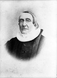 Studioportrett i kvartfigur av en prest.