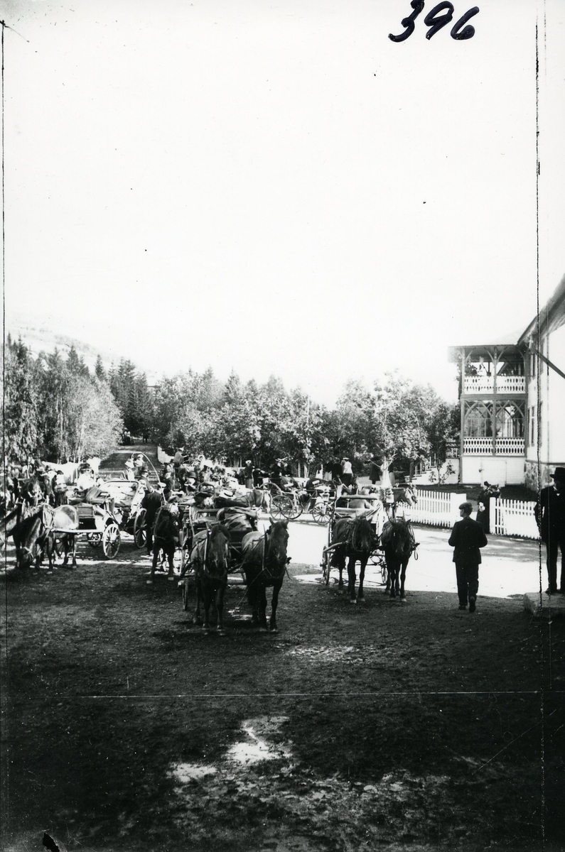 Mennesker, hester og karjoler utenfor Fosheim Hotell. Rundt 1905.