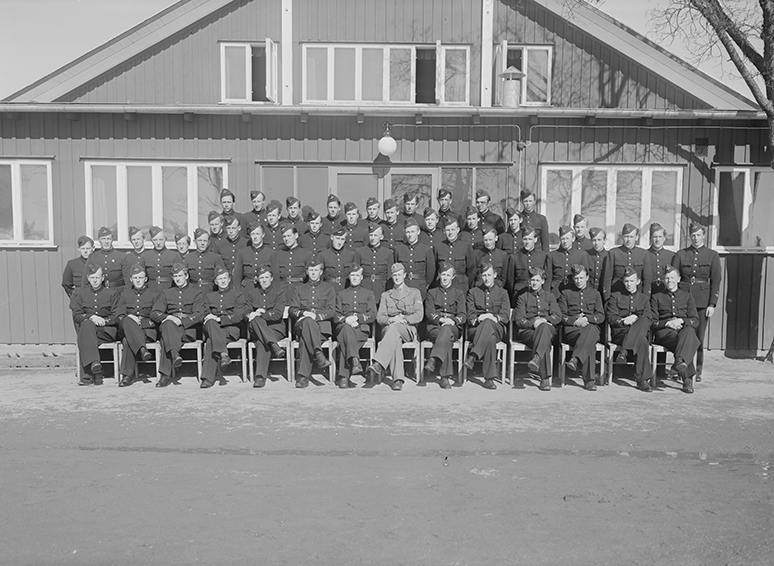 Elever och lärare vid volontärskolan på F 3 Östgöta flygflottilj, 1940-1941. Grupporträtt framför byggnad.