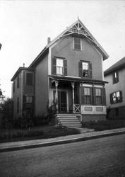 Hus, med parti av fortau og gate i forgrunnen.