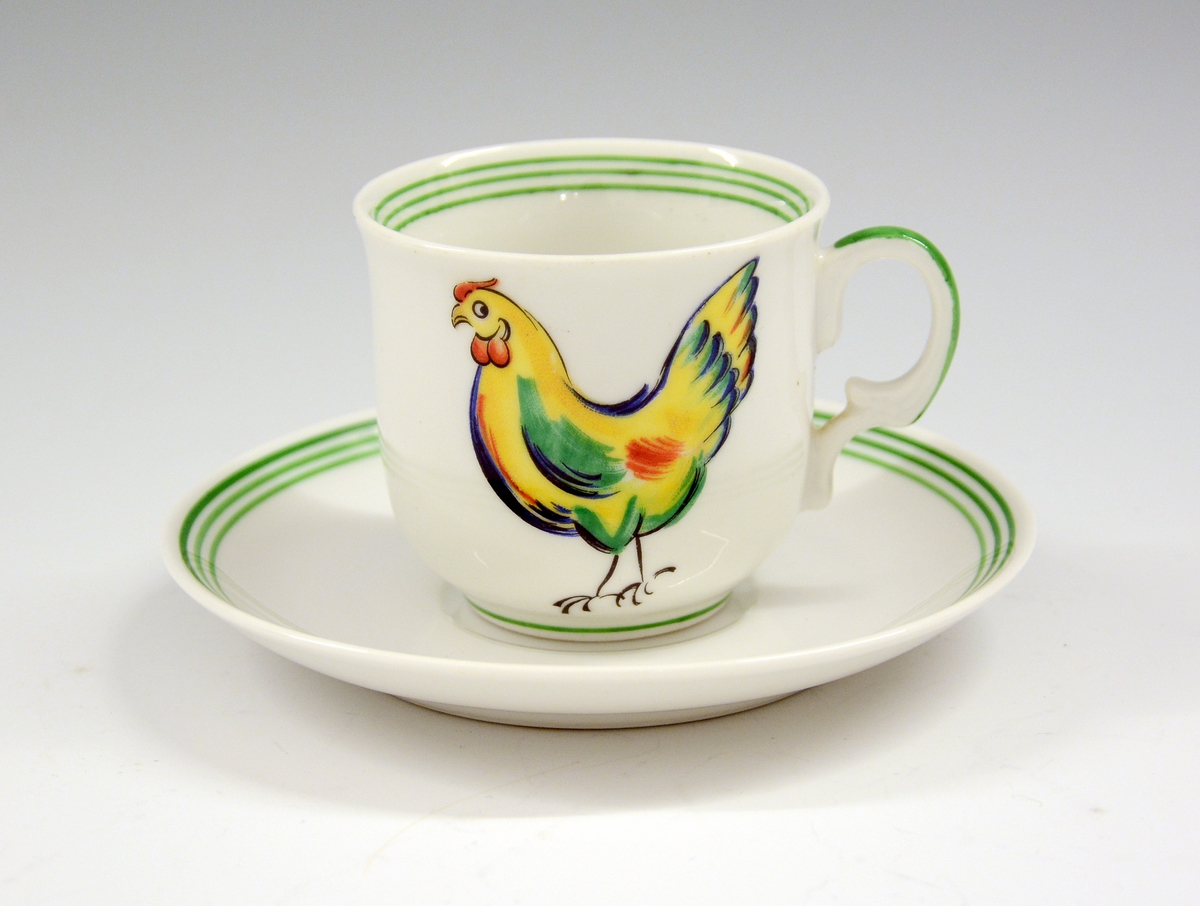 Kaffeskål i porselen til dukkeservise. Hvit glasur. Grønn strek. 
Modell 1460
Dekor "Hønen Petrine 1"