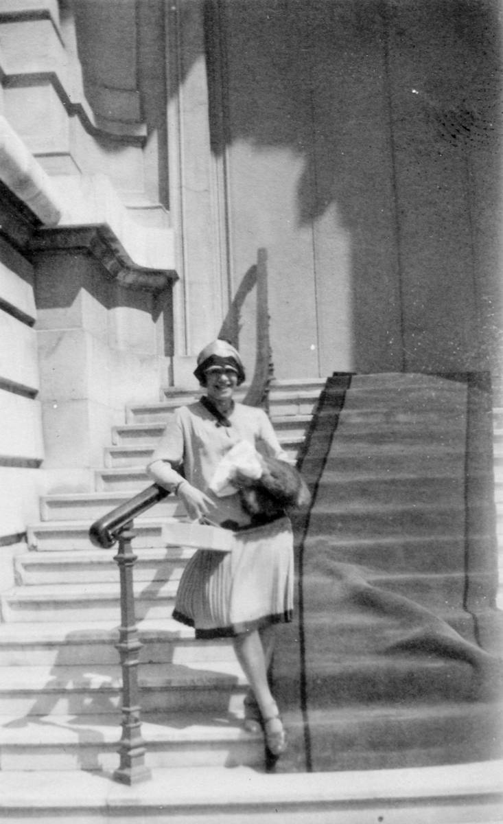 Klara Thams på ei trapp ved inngangen til en større bygning.