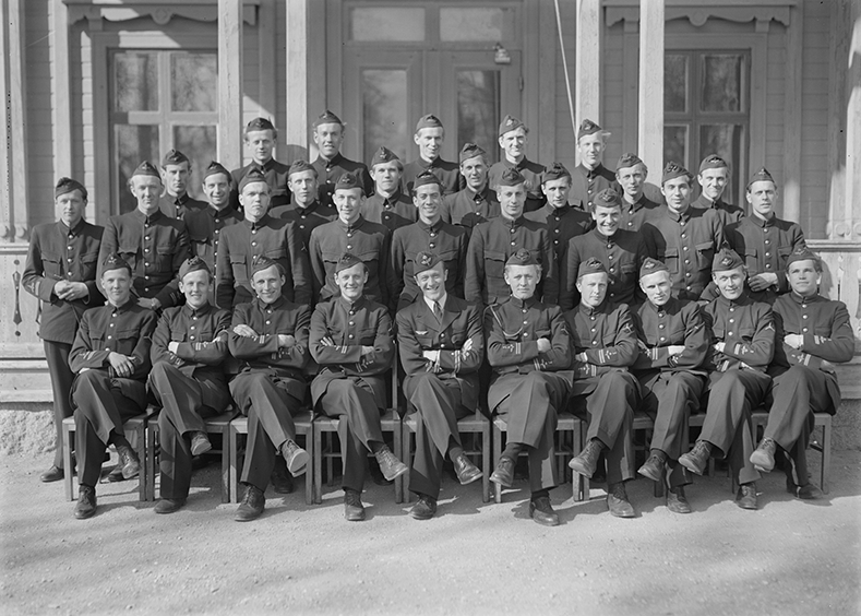Elever vid furirskolan för flygplansmekaniker på F 3 Östgöta flygflottilj, 1947. 32 stycken elever. Grupporträtt framför byggnad. 2 bilder.
